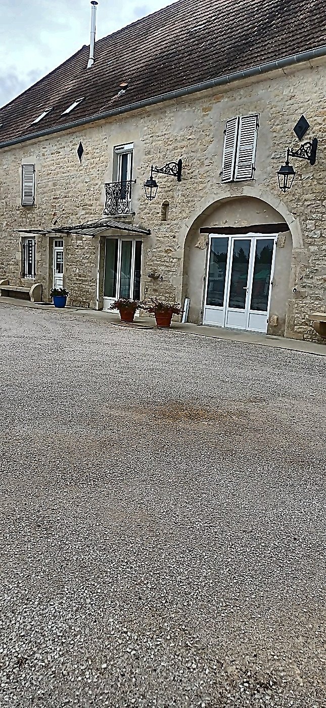 Poteries fleuries et façade en pierre